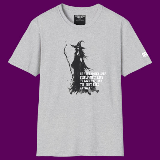 Gothic witch graphic t-shirt featuring a detailed illustration of a witch holding a staff, surrounded by the quote 'Be your spooky self. People don't have to love you, and you don't care anyway.' Designed and sold in The Fright Factory NOLA gothic gift shop.
