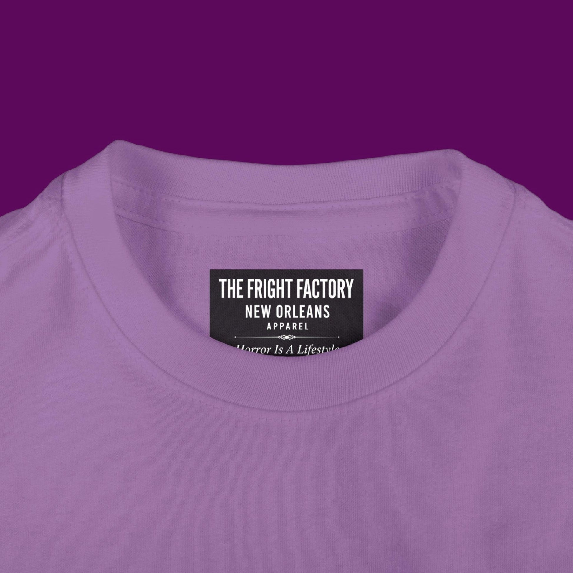 Close-up of a custom Chibi Wednesday Addams inspired goth girl graphic with a personalized name on a purple kids t-shirt. Available in The Fright Factory New Orleans gift shop.