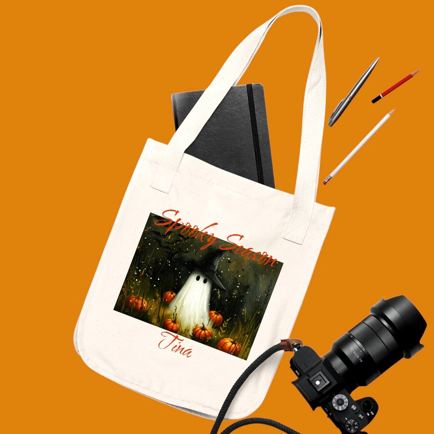 A custom off white 100% organic cotton tote bag featuring a Halloween-themed illustration of a ghost in a witch hat, surrounded by pumpkins. Personalize yours in The Fright Factory New Orleans horror gift shop.